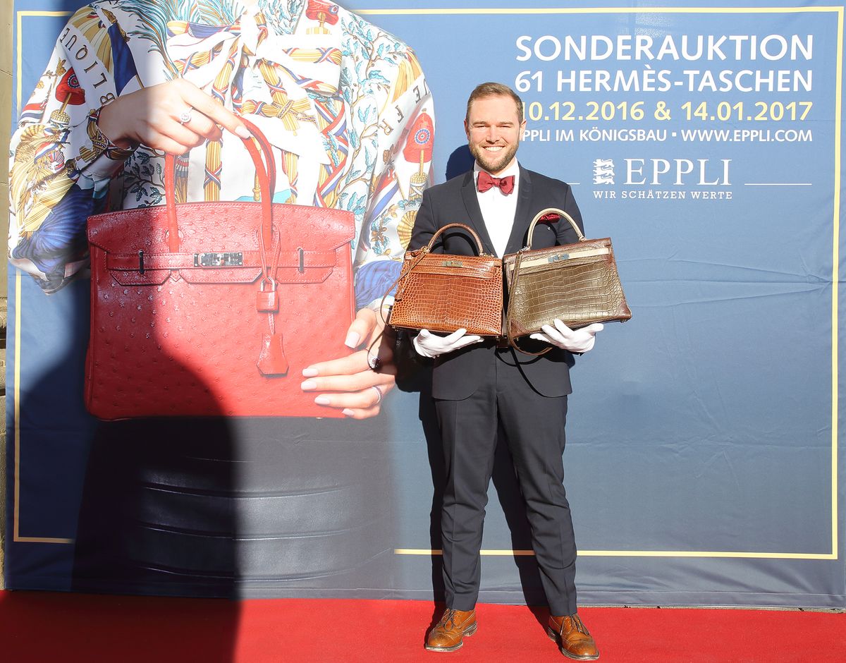 Auktionator Ferdinand B. Eppli zeigt die Kelly Bags